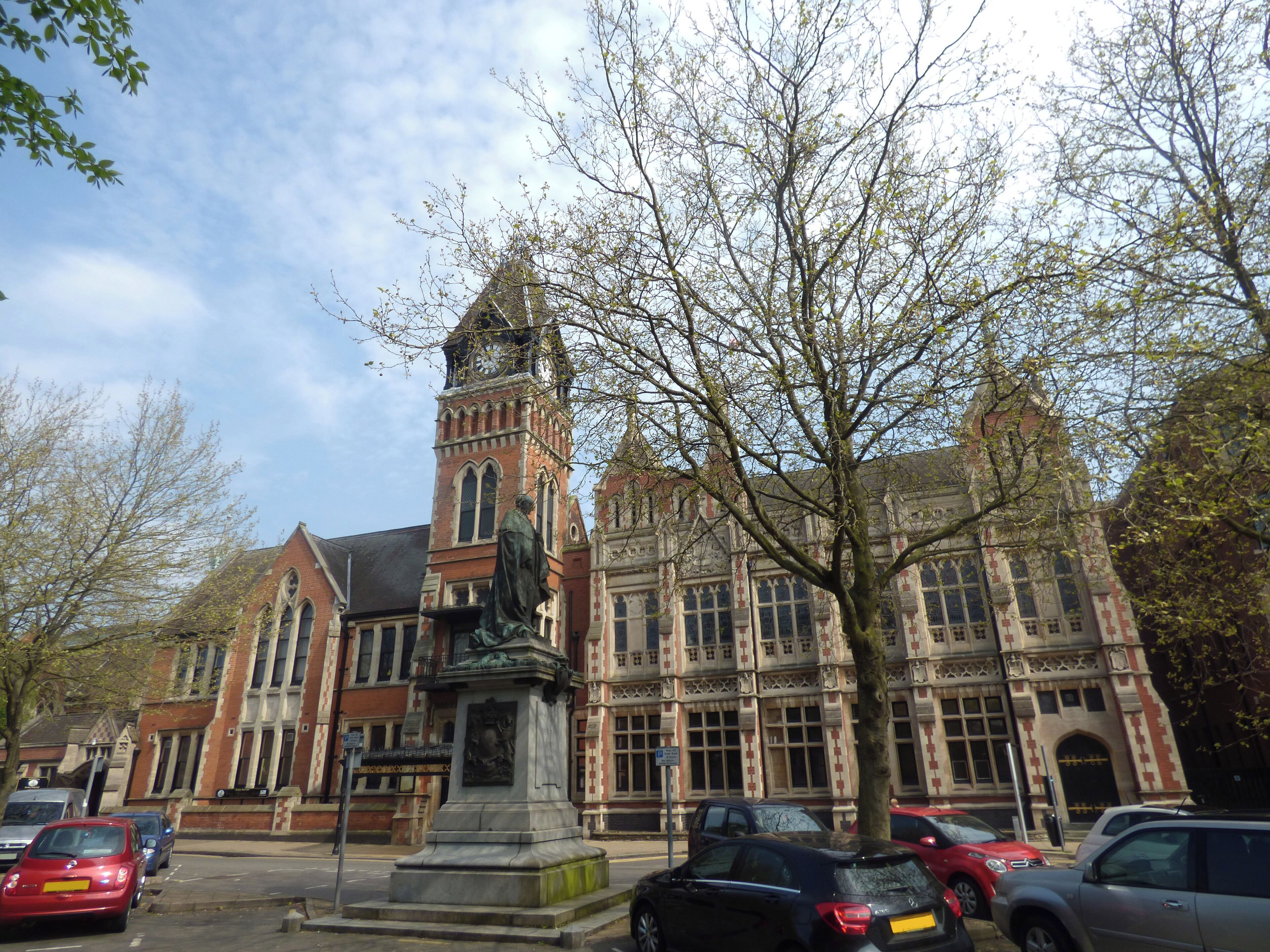 At King Edwards Place in Burton upon Trent. In the Shobnall area of Burton. Burton upon Trent Town Hall. The Town Hall is Grade II listed. Town Hall, Shobnall    KING EDWARD PLACE
   1.
   5369
   Town Hall
   SK 2323 SE 5/95
   SK 22 SW 6/95
    II GV
    2.
   1878 and later. Gothic style. Red brick with stone dressings. The original
   portion built by Reginald Churchill for Michael Thomas Bass. 2 storeys with
   gables. Each bay has a 3-light window in foil-headed stone surround with mullions
   and transom, the lights with foil heads and quatrefoil panels below; elaborate
   decoration with bands of blind quatrefoils at 1st storey and to parapet; coped
   gabled and stone piers with pnnacles supporting figures of lions bearing standards.
   Later portion, on left-hand side, is of 1894 and in similar style, with clock
   tower and doorway below in stone surround and with wrought iron porte-cochere.
   2-storeyed wing to left is of 3 bays, each with 3-light stone mullioned window,
   the centre bay projecting and with gable and angled buttresses. Elaborate
   single-storeyed wing on left-hand side containing Concert Hall has various
   projecting gabled bays with pointed arched windows and an arched doorway to
   right. Tiled roofs.
    Listing NGR: SK2400123438
 The statue is Grade II listed Statue of Michael Arthur Bass, Shobnall    KING EDWARD PLACE
   1.
   5369
   Statue of Michael Arthur Bass
   SK 2323 SE 5/96
    II GV
    2.
   1911. Statue of the 1st Baron Burton (1837-1909) by F W Pomeroy. A conventional
   life-sized bronze statue on a stone plinth.
    Listing NGR: SK2400023405
 This text is a legacy record and has not been updated since the building was originally listed. Details of the building may have changed in the intervening time. You should not rely on this listing as an accurate description of the building. Source: English Heritage Listed building text is © Crown Copyright. Reproduced under licence.
