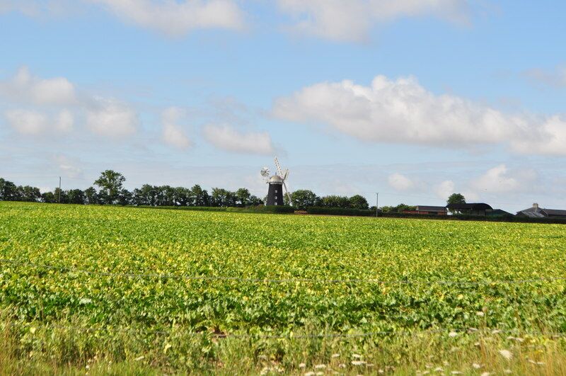 A windmill in a field with a clear sky.
