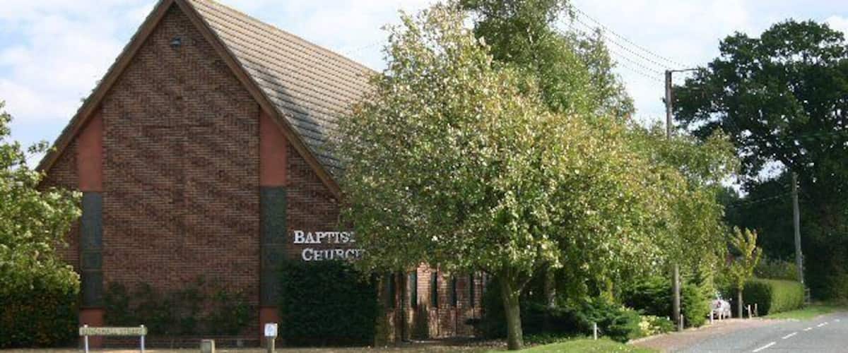 A brick building labeled "Baptist Church" with a road in front.
