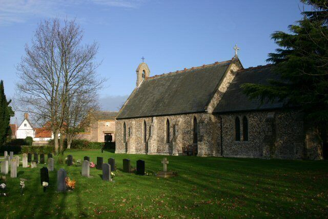 A church with a stone facade and a bell tower, surrounded by a cemetery with headstones.