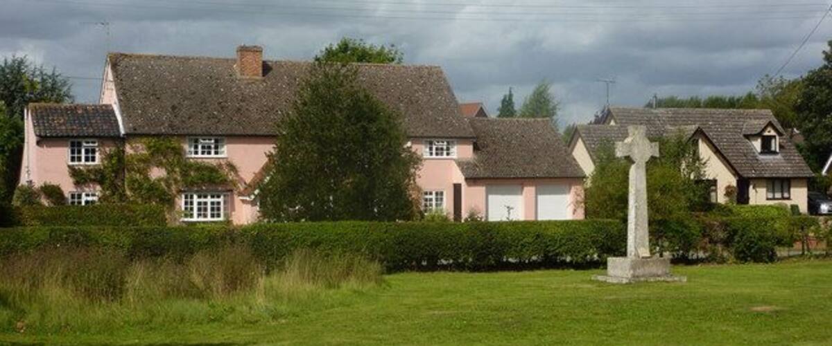 A row of houses with a church cross in the foreground.