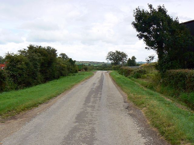 The road past Manor Farm, Grittenham One of the farm buildings can be seen at the right as the road leads away to the east.