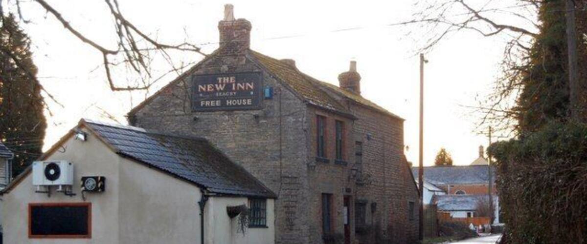 A building labeled 'The New Inn Free House' on a rural road.