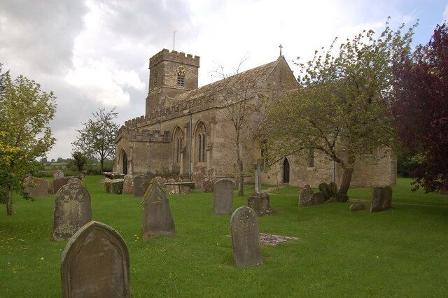 A church with a tower and a graveyard with headstones.