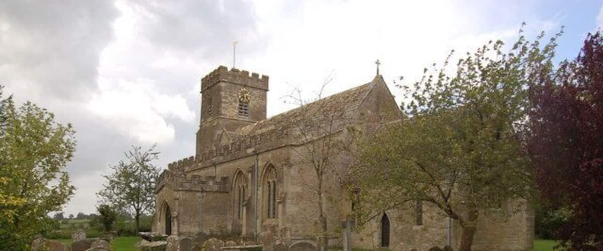 A church with a tower and a graveyard with headstones.