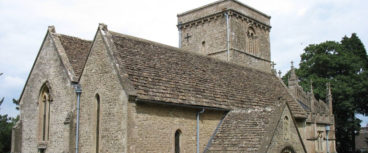 A historic stone church with a bell tower and arched windows.