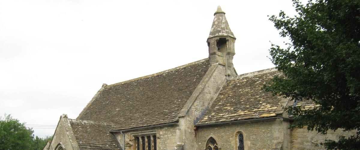 A historic church with a stone facade, a pointed steeple, and a surrounding graveyard with headstones.