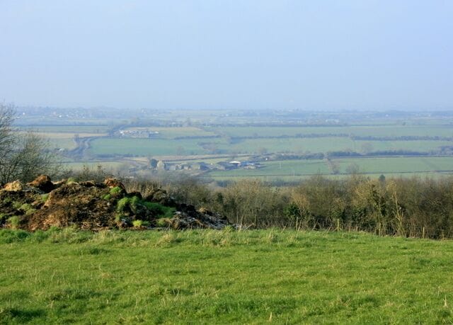 North west from Hinton Hill A pasture in the foreground with a pile of - well - something. Looking in the direction of Westerleigh and Coalpit Heath with the M4 running across the picture in between, thankfully out of sight :-). Not sure where the buildings near the bottom of the hill are, they are probably in the outer regions of Hinton.