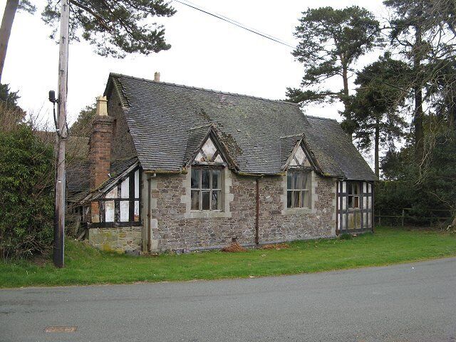 A stone cottage with a tiled roof and white-framed windows.