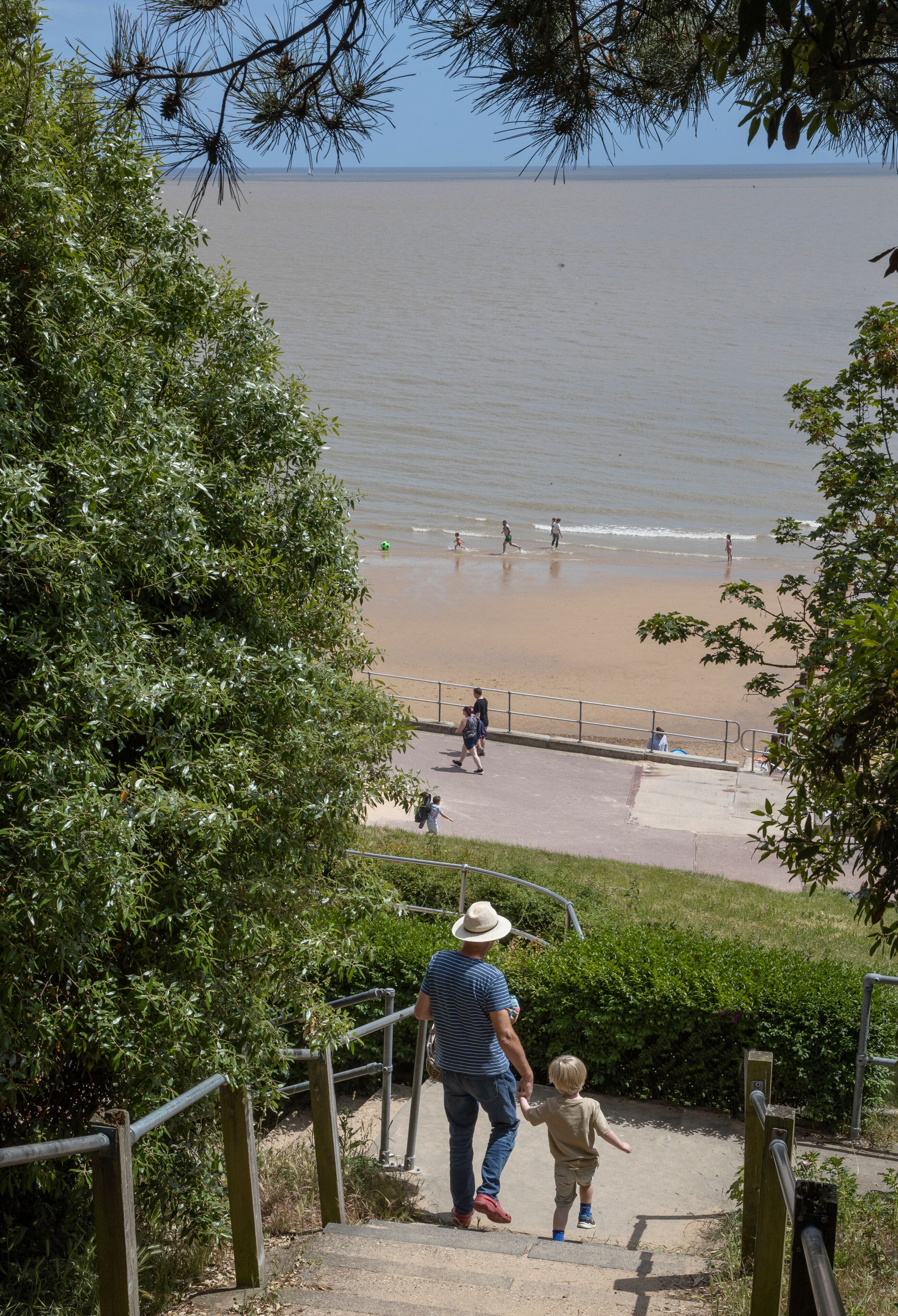 Walking to the beach with granddad. Boy and man. Stairs.Coast. Frinton on sea.. Northsea. England. Essex. UK. Great Brittain.