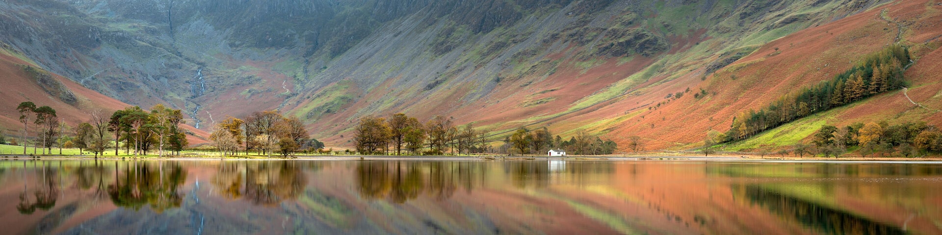 Buttermere panorama with perfect reflections taken on a calm Autumn morning in the Lake District, UK.