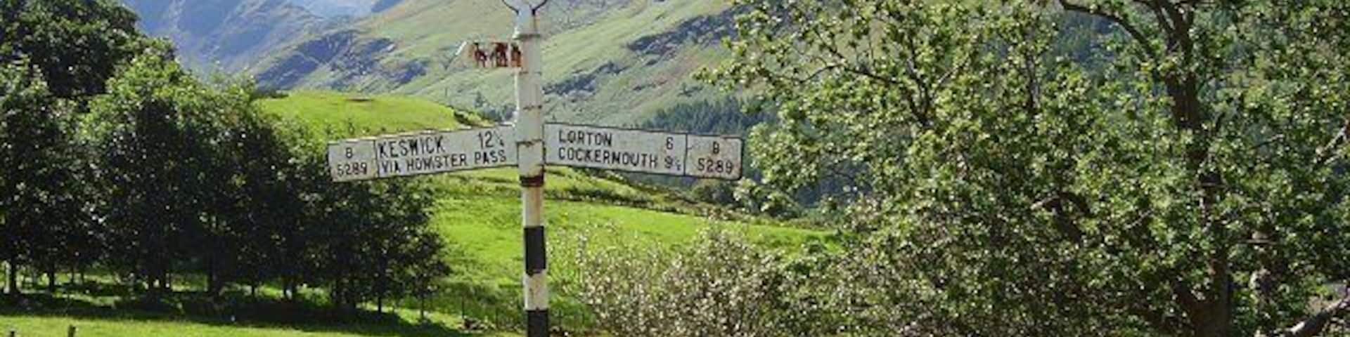 Signpost, Buttermere Old cast iron Cumberland C.C. signpost. When erected, the two passes out of the village must have been formidable obstacles. Now all three roads are hard going because of the volume of traffic. (All but the foreground and signpost are in another square.)