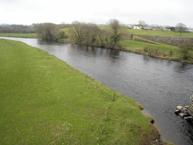 Looking up the River Derwent from Broughton Bridge The houses on the far bank are the outskirts of Brigham village.