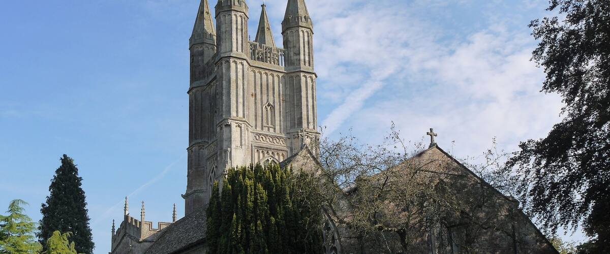 A historic church with a tall tower and a smaller adjacent building.