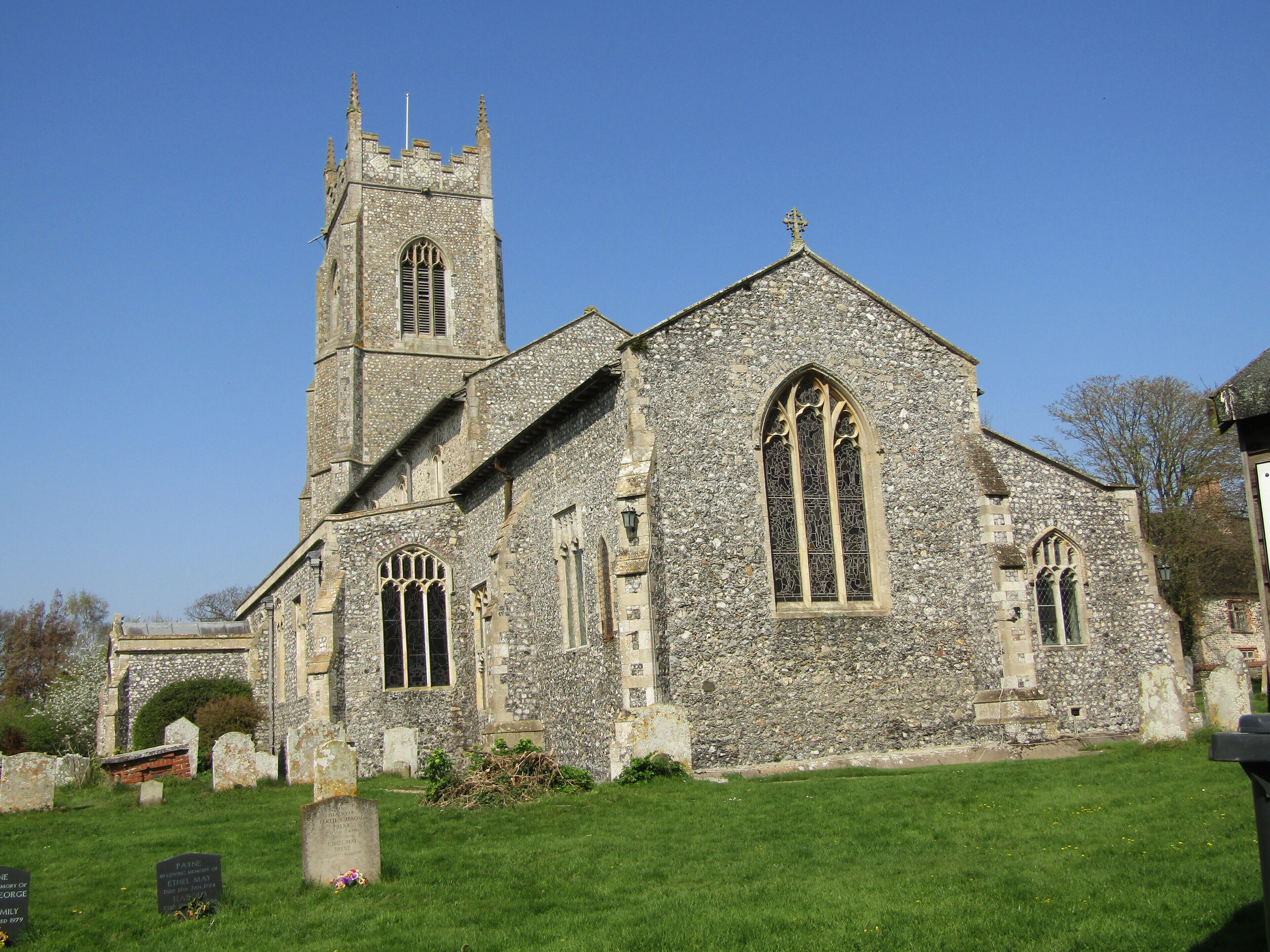 A historic stone church with a tall tower and arched windows.