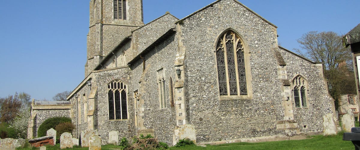 A historic stone church with a tall tower and arched windows.