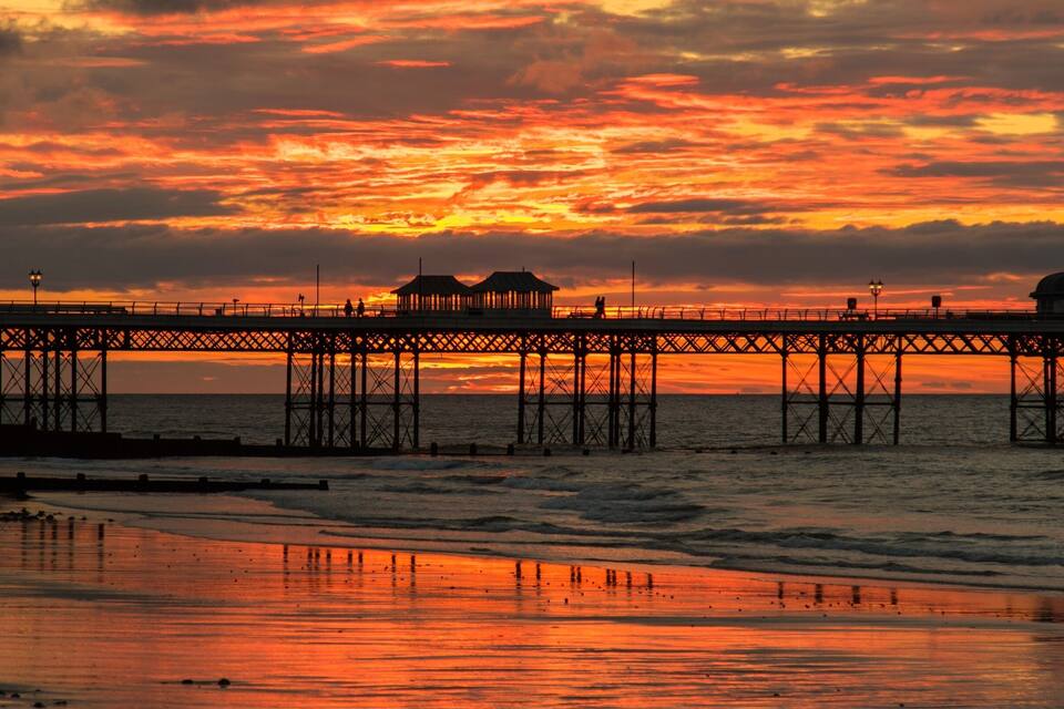 A pier with a sunset in the background.