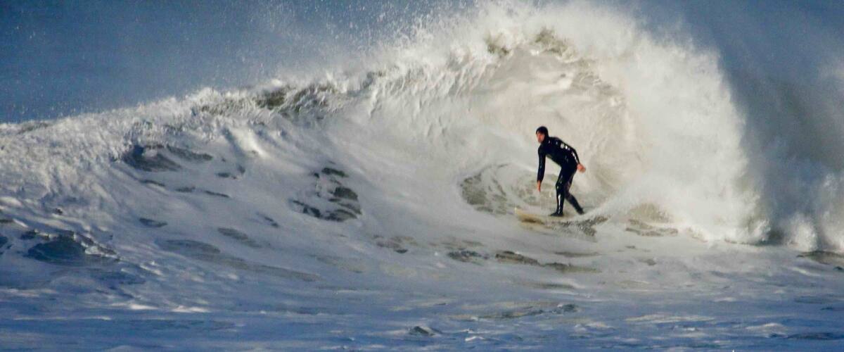 A surfer riding a large wave in the ocean.