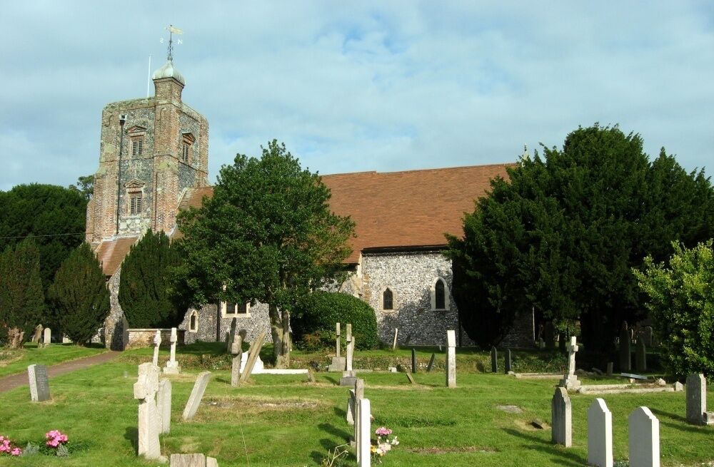 A church with a tower and a cemetery with gravestones.