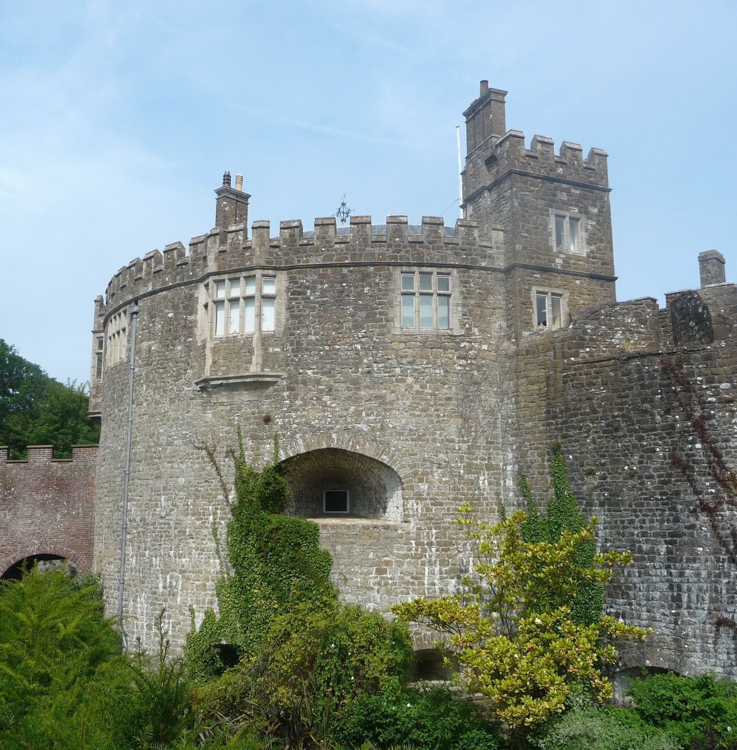 A historic stone castle with battlements, arched windows, and a central tower.