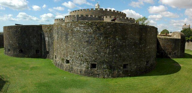 A historic stone castle with a round tower and a central keep.