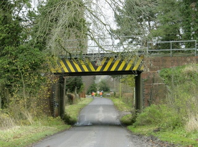 Railway bridge over Lower Road Near Erlestoke. The bridge carries the main line between Westbury, Newbury and Reading. Network Rail maintenance workers are preparing for a line inspection. The heavier stone trains were travelling slower than usual here.