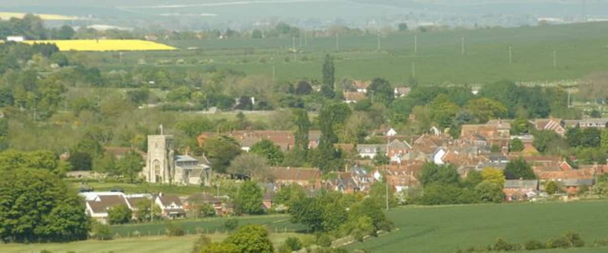 A rural village with a church, houses, and surrounding fields.