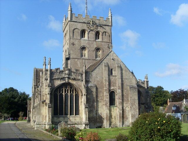 A historic church with a tall tower, large arched windows, and a stone facade.