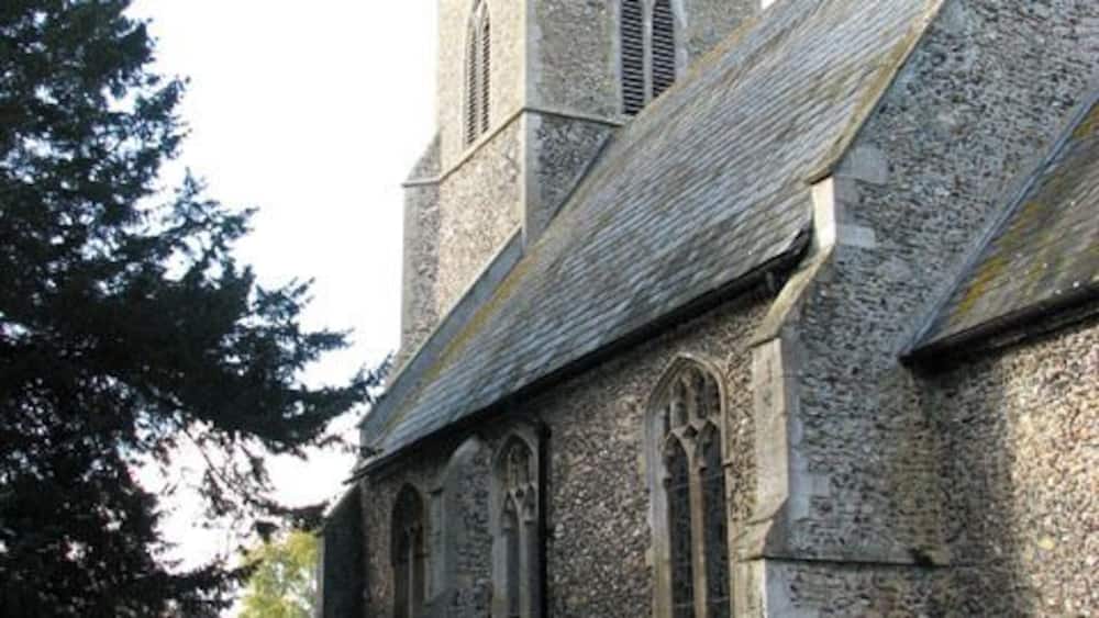 A church with a stone tower and arched windows.