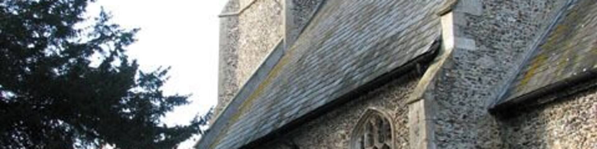 A church with a stone tower and arched windows.