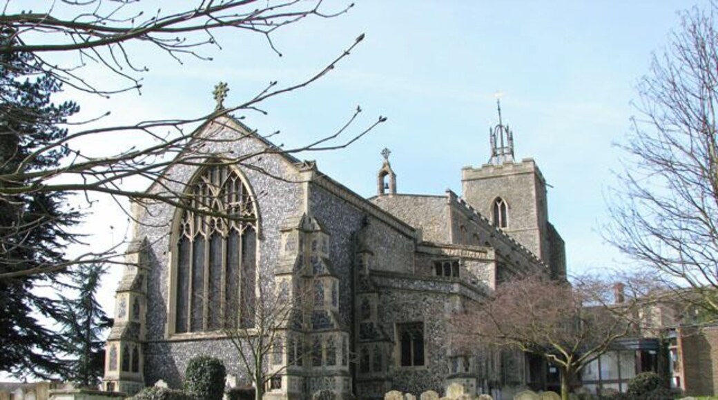 The church of St Mary in Diss. St Mary's Church > 1768170 is situated above Mere Street and the Market Place. The building has a tower with open arches underneath - this ensured that processions around the church, as was customary in medieval times, could pass through and remain within the church precincts. Built from local flint and limestone from Normandy, St Mary's church was started in 1290, with two side chapels added between 1430 and 1440. The west window in the south chapel contains medieval stained glass > 1768959 but all other windows are reconstructions > 1768945 of earlier ones and date from between 1866 and 1882. The east window > 1768909 is by Francis W Oliphant and was installed around 1857 when the chancel was extended and the small square window was replaced by the present one. The baptismal font > 1768971 was made in 1857.