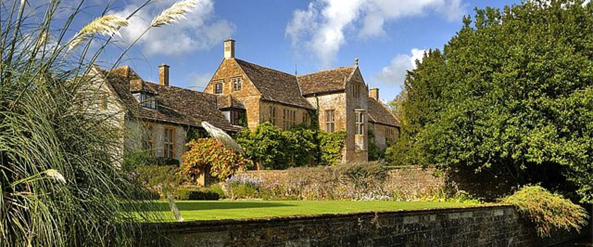 A historic building with a stone wall and a canal.