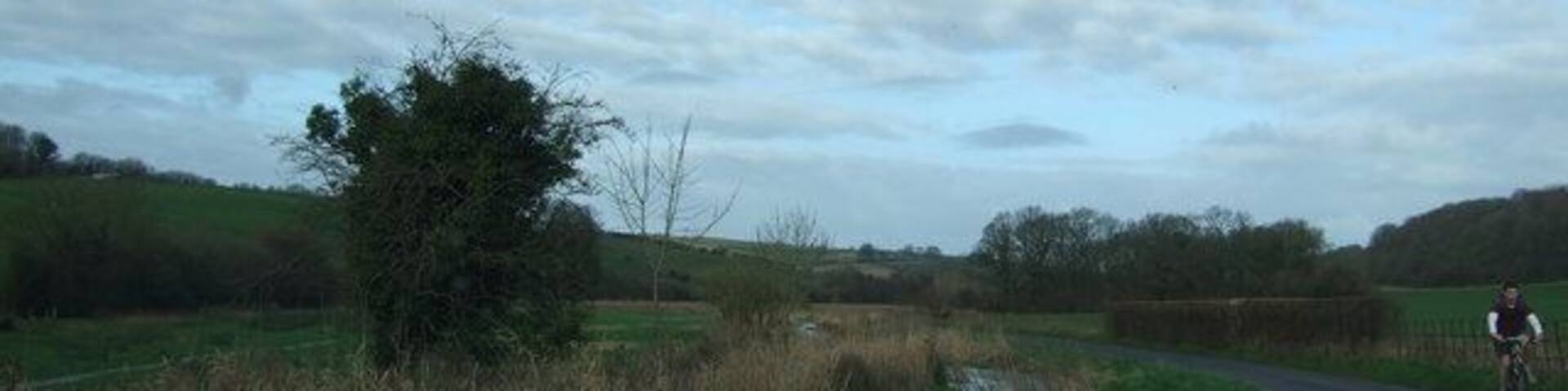 Sydling Valley with river alongside the road A lovely unspoilt valley teeming with wild life, although only a cyclist in view