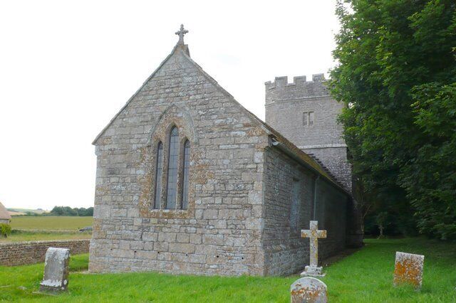 A stone church with a bell tower and a graveyard.