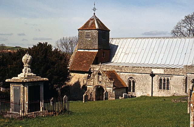 A church with a bell tower and a stone fountain in the foreground.