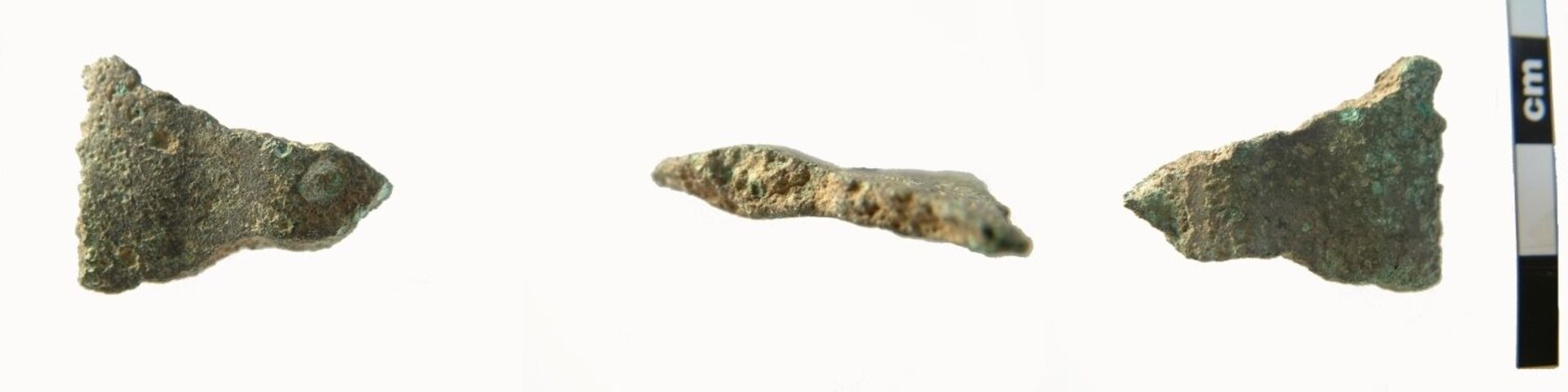 Possible fragment of Late Bronze Age sword of the Carps Tongue type. In section this fragment has a prominent mid-rib 5.4mm thick and c.10mm wide. One side of this is missing (probably recent damage). On the other side the blade extends c.11mm, thickening after it narrows either side of the mid-rib, then thinning towards the blade edge which is missing its bevelled edge, also due to recent damage. The metal is dark green in colour and has a rough feel. The fragment measures 26.7mm wide (probably originally c.38-40mm wide), is 20.1mm in length and max5.4mm thick. It weighs 7.01g. Carps Tongue swrods date from the 9th to 8th century BC.