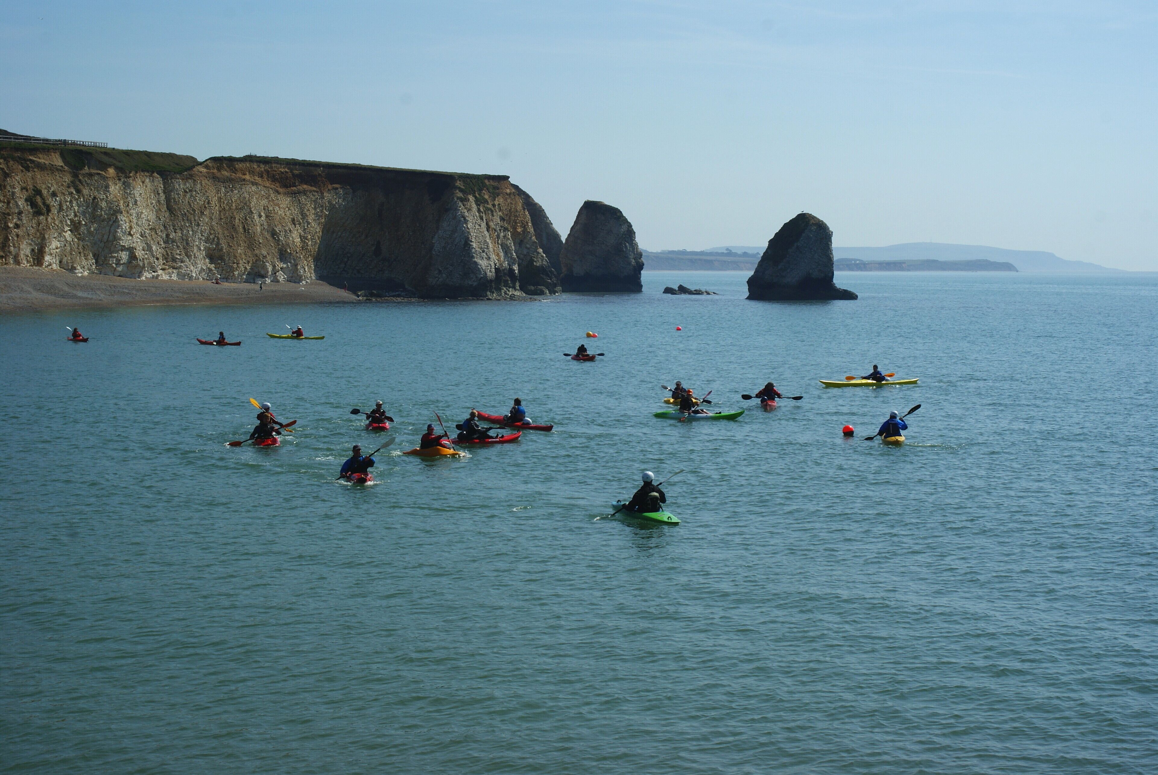 Canoes in Freshwater Bay, Isle of Wight Looking towards Stag Rock, on the right; Mermaid Rock, and the remains of Arched Rock. The canoeists had calm conditions, with hardly a breeze.