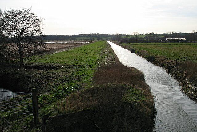 The South Drain Taken from the old railway bridge, this shows the South Drain as it flows northwards to meet the Glastonbury Canal. Both then head west-north-west across the Somerset Levels towards the Bristol Channel. On the left is part of Walton Heath. More specifically, the area seen in the photograph is a former peat excavation area which was known as 'Signal Pole' and was worked by Fisons PLC. A lot of the fields or 'grounds' where peat excavation took place were given names. It is now flooded and forms part of the Ham Wall Reserve.
