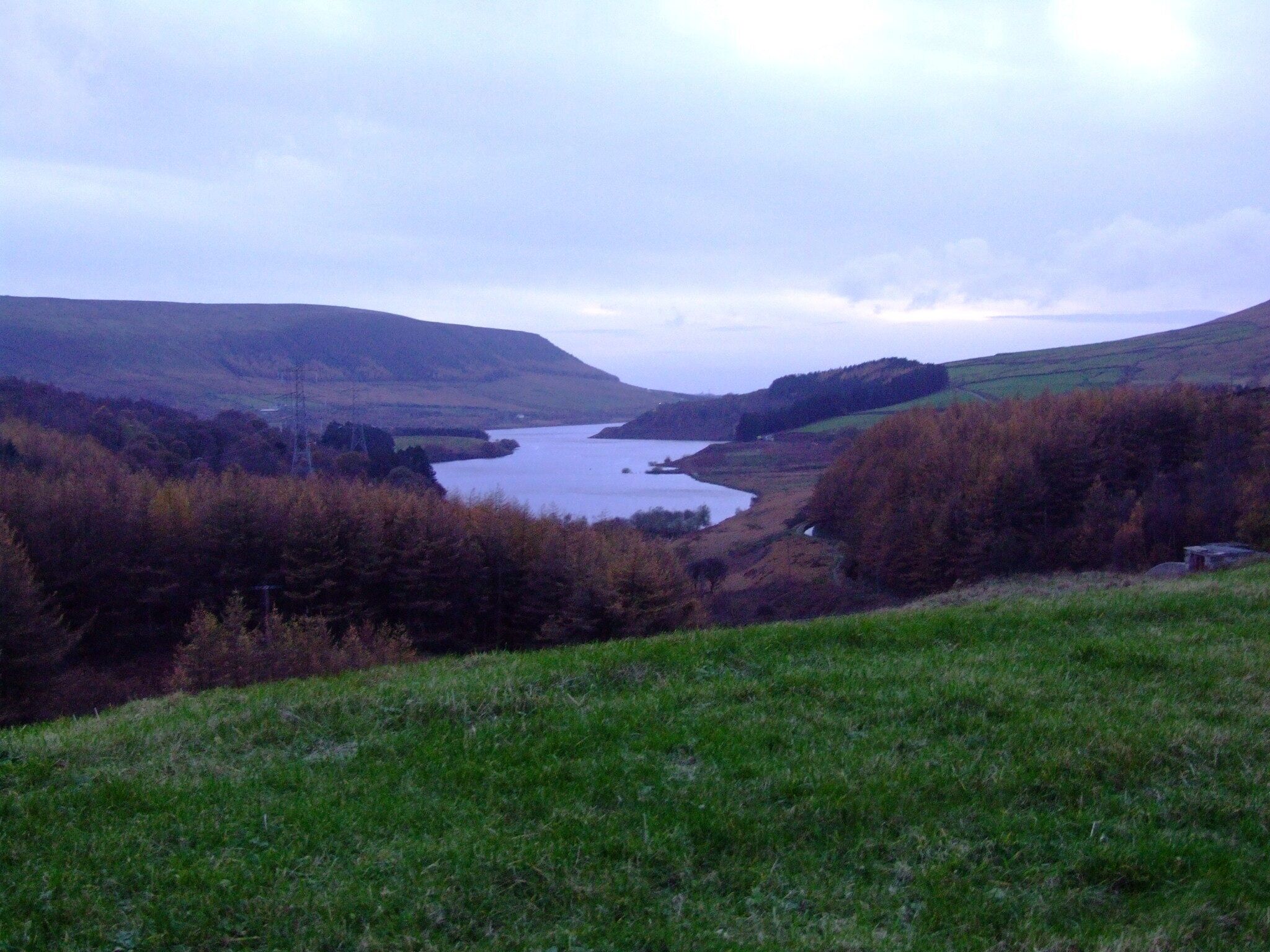 Longdendale in Derbyshire is the valley of the River Etherow. The Longdendale Chain is a series of reservoirs built to provide drinking water forManchester. The Woodhead reservoir is the highest in the chain, and the last to be finished. Taken from the 1992 embankment (6.7m above the 1877 original level) , This is a view over Torside Reservoir. Weather and light difficult. Camera location 53° 29′ 28.74″ N, 1° 52′ 45.29″ W View this and other nearby images on: OpenStreetMap - Google Earth 53.491317; -1.879247