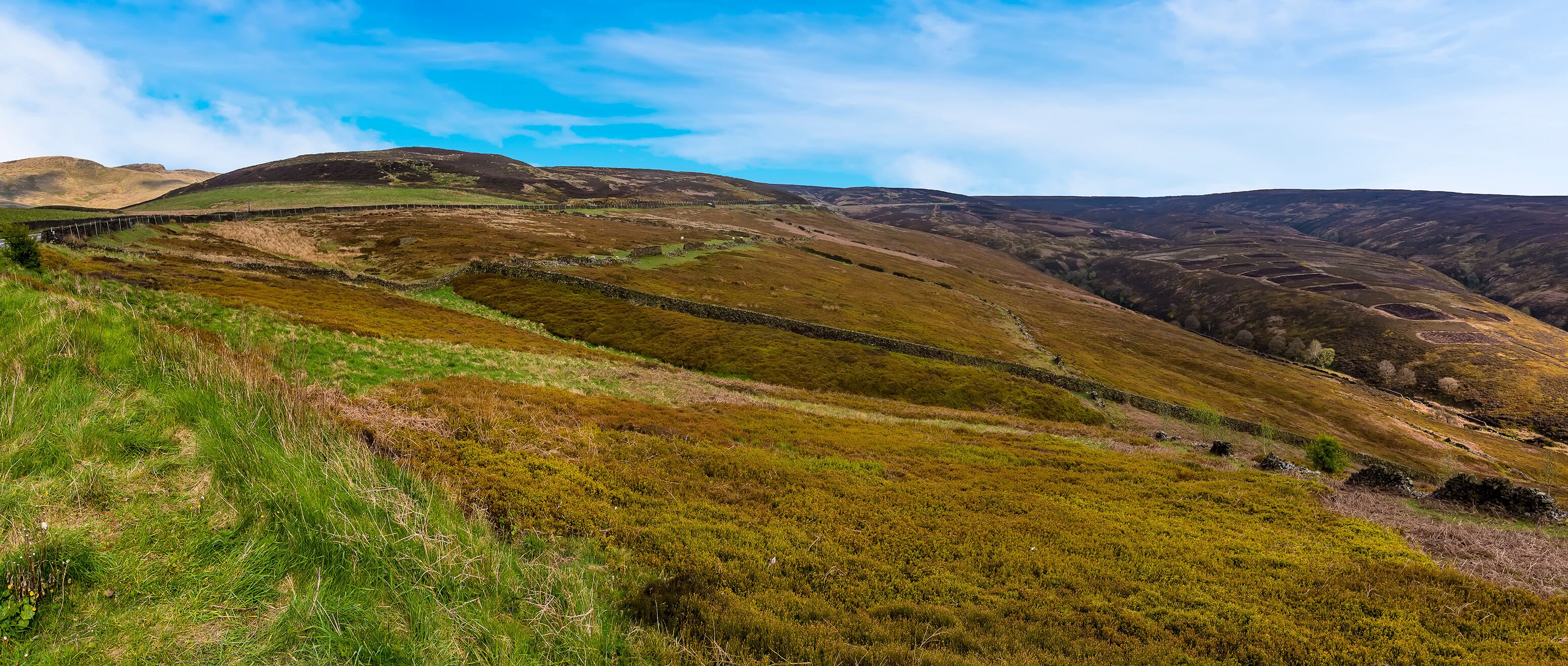 A hilly landscape with stone walls and green vegetation.