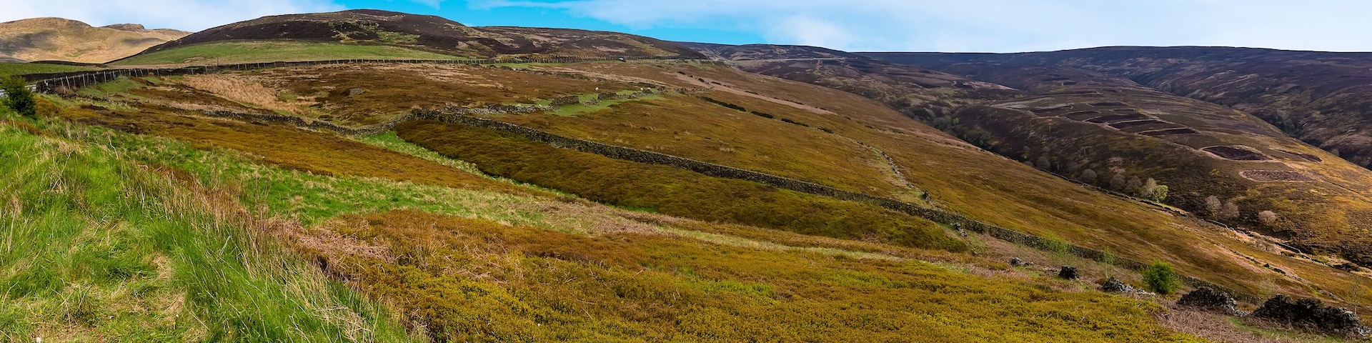 A hilly landscape with stone walls and green vegetation.