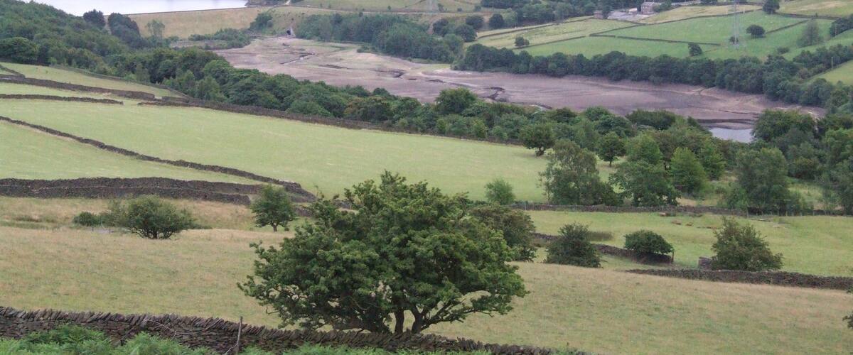 Tintwistle Low Moor is to the north of Longdendale, where the reserviors of the Longdendale Chain provide water for Manchester, and compensation water for the River Etherow During the drought of 2010 Valehouse Reservoir was empty. Rhodeswood behind, then further Torside. Bleaklow in the distance.