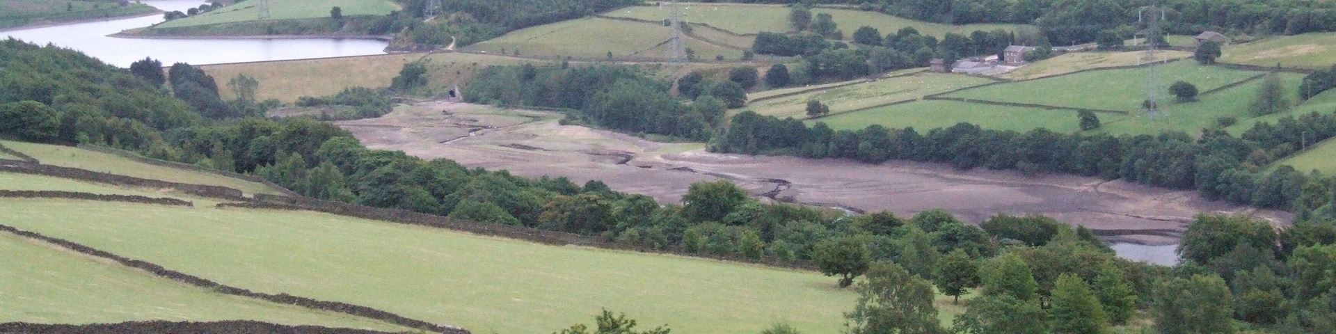 Tintwistle Low Moor is to the north of Longdendale, where the reserviors of the Longdendale Chain provide water for Manchester, and compensation water for the River Etherow During the drought of 2010 Valehouse Reservoir was empty. Rhodeswood behind, then further Torside. Bleaklow in the distance.