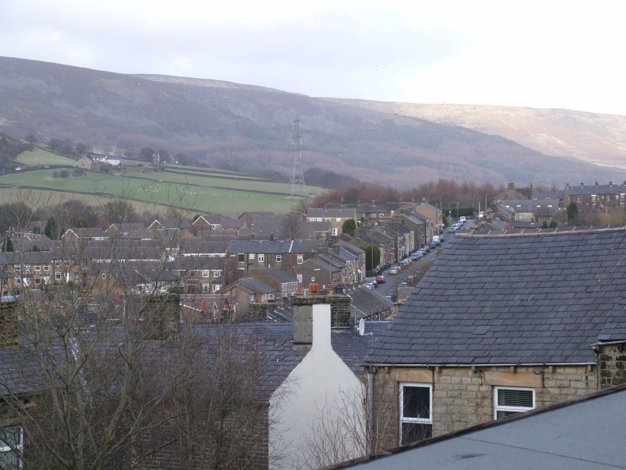Hadfield is a village in Longdendale Derbyshire on the edge of Greater Manchester. From Banks street, looking over the rooves, along Bosscroft to Longdendale. Camera location 53° 27′ 48.96″ N, 1° 58′ 18.12″ W View this and other nearby images on: OpenStreetMap - Google Earth 53.463600; -1.971700