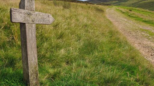 Sign pointing 'to open country' next to farm