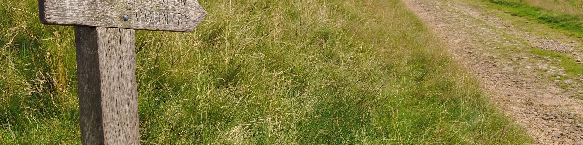 Sign pointing 'to open country' next to farm