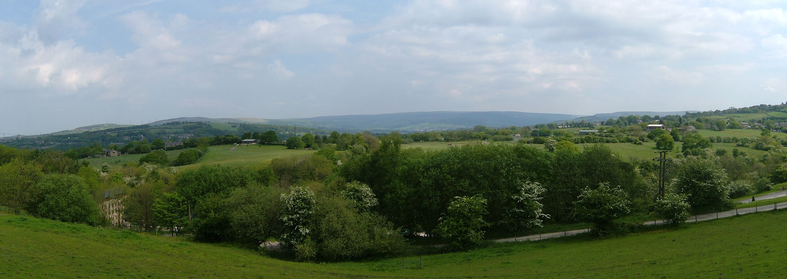 Rolling hills, a road, and scattered buildings.