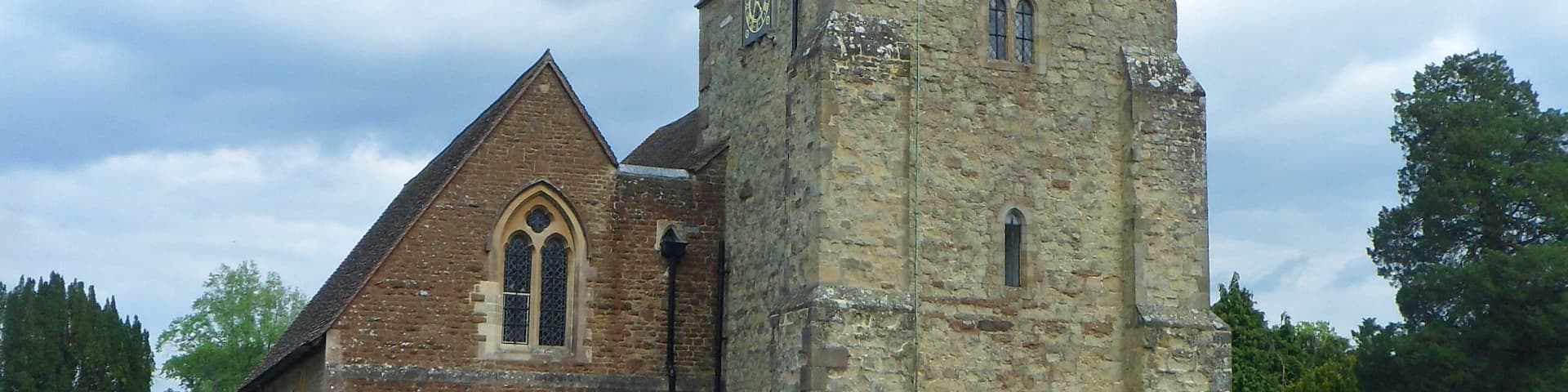 A church with a prominent tower and a graveyard in front.