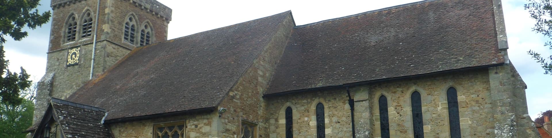 A historic church with a tall bell tower and a graveyard in front.