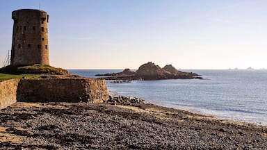 A coastal landscape with a stone tower and rocky outcrops.